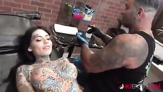 Молодая брюнетка делает татуировку на лбу голой